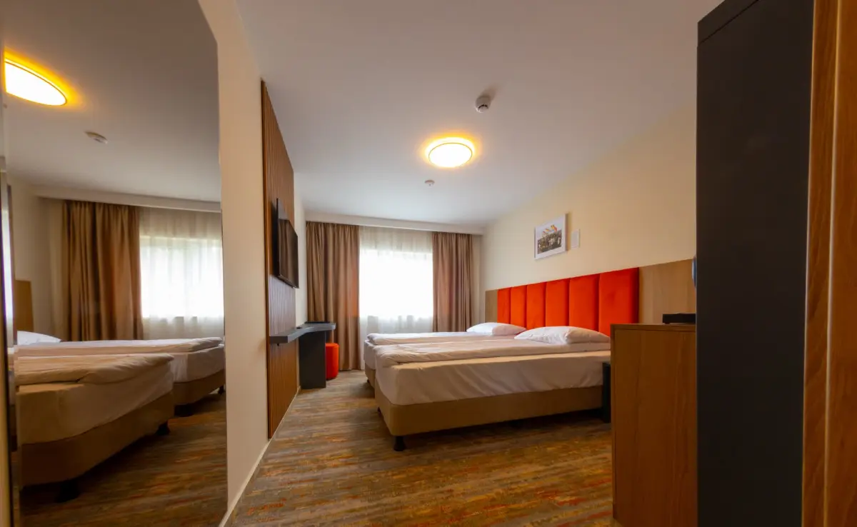 Cameră renovată recent la Hotel Cetate, cu lemn cald și textile roșii